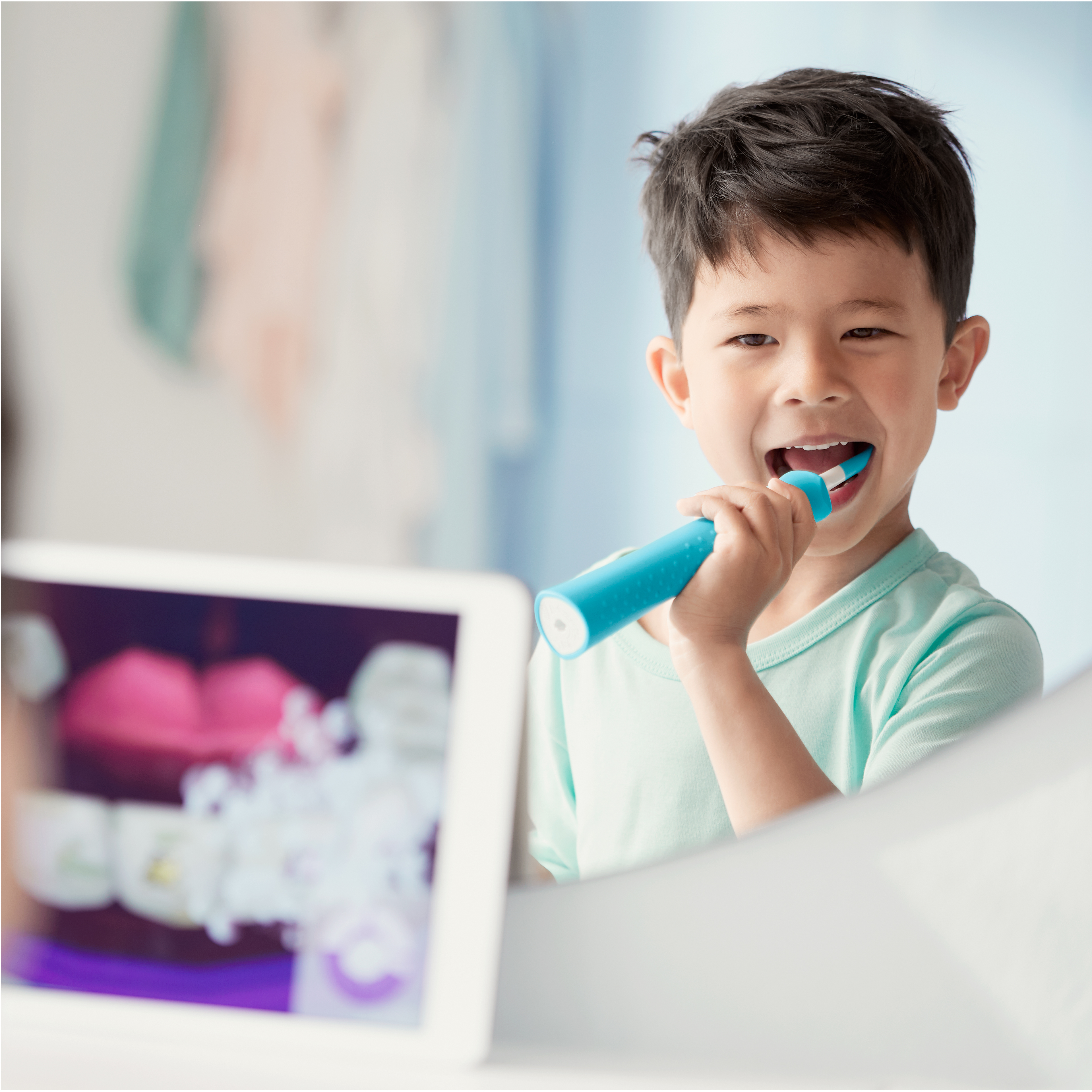 Jongen poetst met een Sonicare for Kids-tandenborstel terwijl hij naar de Sonicare for Kids-app kijkt